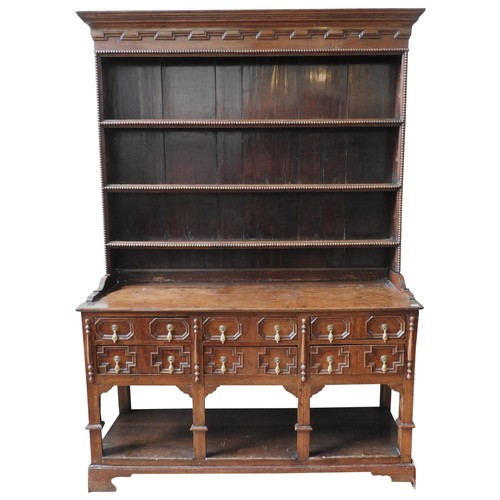 94 - A 19TH CENTURY OAK DRESSER, comprised of a three tier bobbin carved plate rack sat atop a rectangula... 