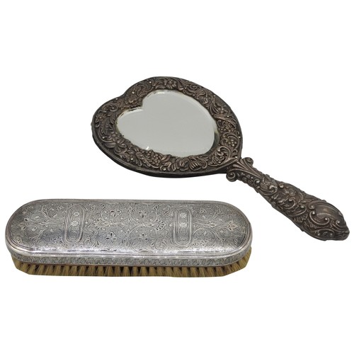 507 - A SILVER MOUNTED HEART SHAPED HAND MIRROR AND AN ORNATE NIELLO DECORATED BRUSH, the mirror with scro... 