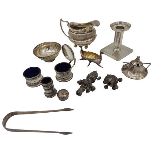 513 - A GROUP OF MIXED SILVER ITEMS, including a boat form jug, weighted candlestick, three piece cruet se... 