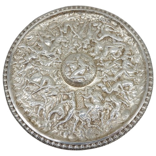 530 - A DECORATIVE CIRCULAR WHITE METAL PANEL, profusely decorated in low relief with a highly detailed ba... 