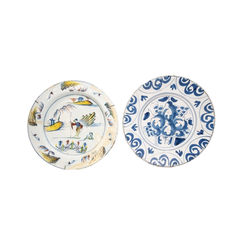 302 - AN 18TH CENTURY DELFT DISH, the centre painted with fruits enclosed by scrolling reserves, along wit... 