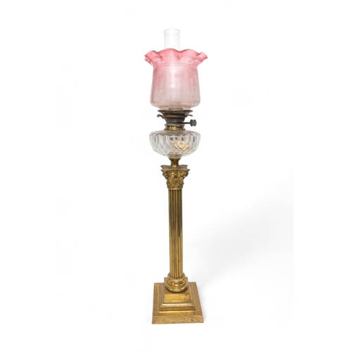 69 - A VICTORIAN OIL LAMP with a large brass Corinthian column reeded base, cut glass reservoir and etche... 