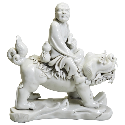 57 - A BLANC-DE-CHINE FIGURE OF A LOHAN20TH CENTURYmodelled as the lohan riding a Buddhist lion, apocryph... 