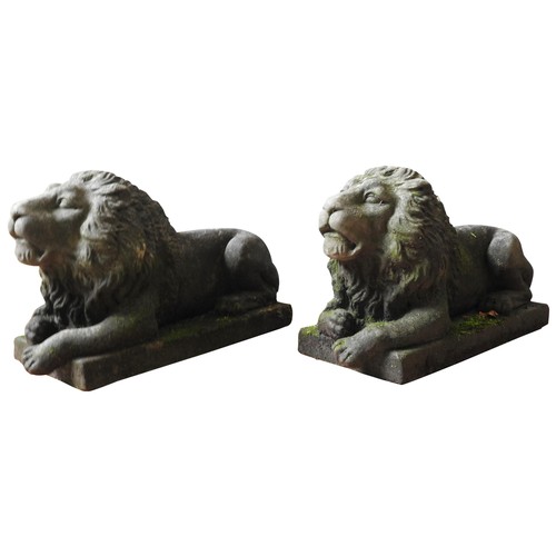 128 - A PAIR OF ORNAMENTAL GARDEN LIONS, 20TH CENTURY, cast composite stone recumbent figures, of good wea... 