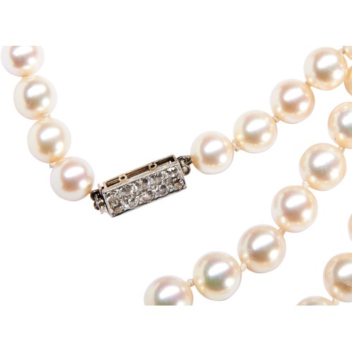 324 - A CULTURED PEARL NECKLACE ON AN ART DECO DIAMOND CLASPthe uniform row of cultured pearls on an oblon... 