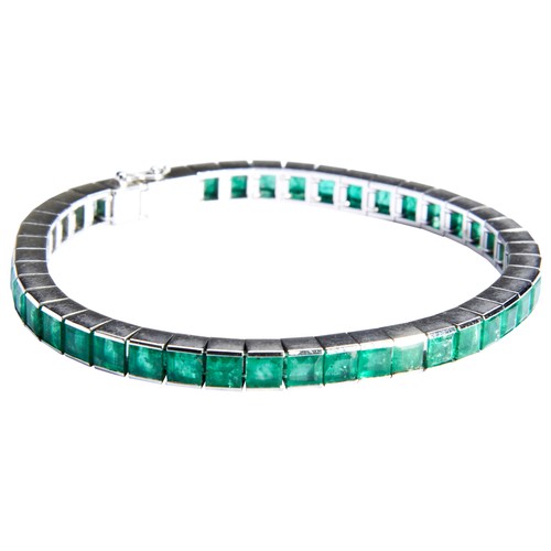 325 - AN ART DECO EMERALD BRACELETthe uniform row of step-cut emeralds in articulated settings, concealed ... 