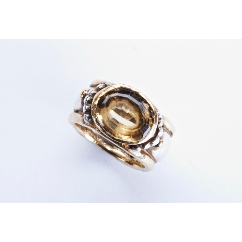 314 - CITRINE, SILVER AND GOLD RINGthe oval mixed-cut citrine collet set in a heavy silver and gold band w... 