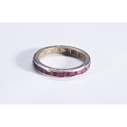 338 - AN EDWARDIAN RUBY ETERNITY RINGchannel set with step-cut rubies, engraved borders.Total weight 2.5gm... 