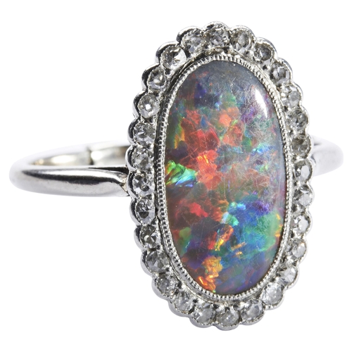 339 - AN EDWARDIAN BLACK OPAL AND DIAMOND RINGthe oval-cut opal millegrain collet set within a border of t... 