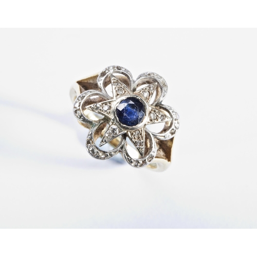 343 - A SAPPHIRE AND DIAMOND RING, CIRCA 1900the circular mixed-cut sapphire collet set within a six ray s... 