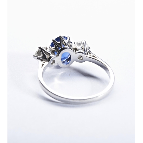 329 - A SAPPHIRE AND DIAMOND THREE STONE RINGthe oval mixed-cut sapphire,  set between brilliant-cut diamo... 