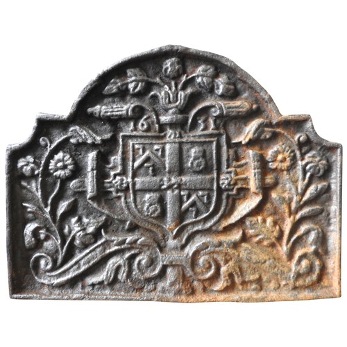 137 - A CAST-IRON FIRE BACK, 19TH CENTURY with a central armorial crest surrounded by scrolling blossoming... 
