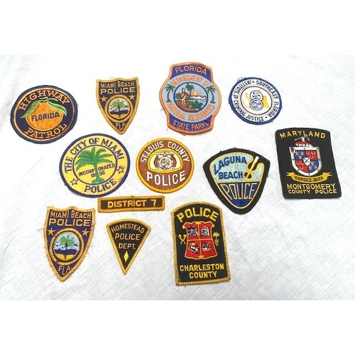 70 - OVER 50 US AND GERMAN POLICE BADGES Over 50 sew-on and cast metal badges covering many US cities, co... 