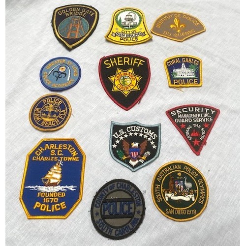 70 - OVER 50 US AND GERMAN POLICE BADGES Over 50 sew-on and cast metal badges covering many US cities, co... 