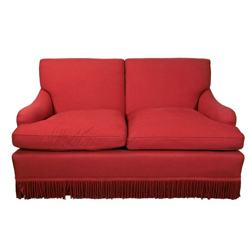 486 - A SCARLET UPHOLSTERED TWO SEAT SOFA with a wool bullion fringe raised on brass casters.90cm x 163cm ... 