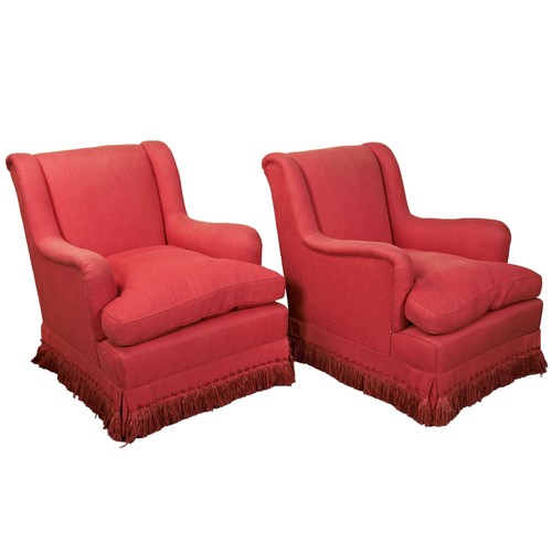 487 - A PAIR OF COLEFAX AND FOWLER RED UPHOLSTERED ARMCHAIRS with fringed edges raised on brass castors91c... 