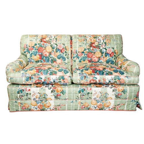 506 - A CALICO UPHOLSTERED TWO SEAT SOFA, 20TH CENTURY, by Colefax and Fowler, with a green chintz loose c... 