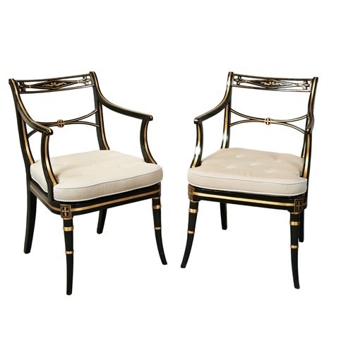 517 - A PAIR OF DARK GREEN AND PARCEL GILT PAINTED ELBOW CHAIRS, with caned seat panels and loose squab cu... 