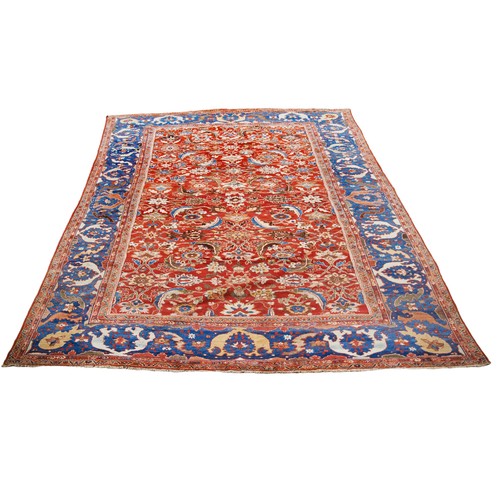 612 - A GOOD QUALITY TURKISH RUG, deep blue border enclosing scrolling floral motifs on a rich red ground3... 