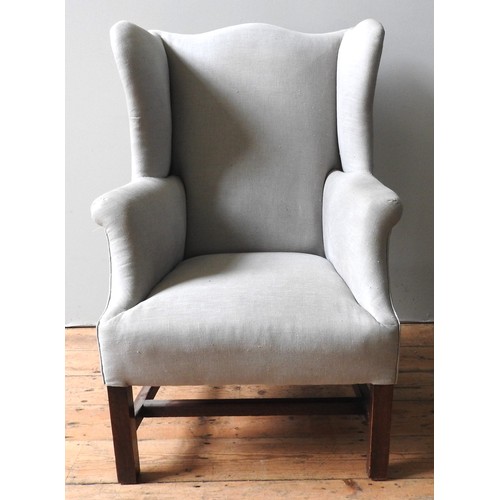 47 - A GEORGE III WING ARMCHAIR, shaped camel back over wide seat flanked by out scrolling arms, raised o... 