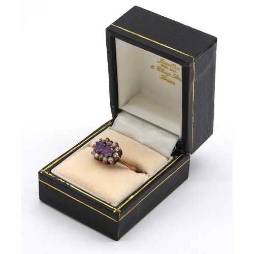 458 - A 9CT GOLD AMETHYST SET DRESS RING, the two amethyst stones enclosed by twelve C.Z stones, the shank... 