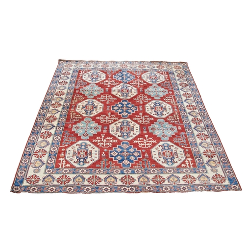 149 - AN AFGHAN KAZAK RUG, LATE 19TH / EARLY 20TH CENTURY, repeating geometric motifs on a rich red ground... 