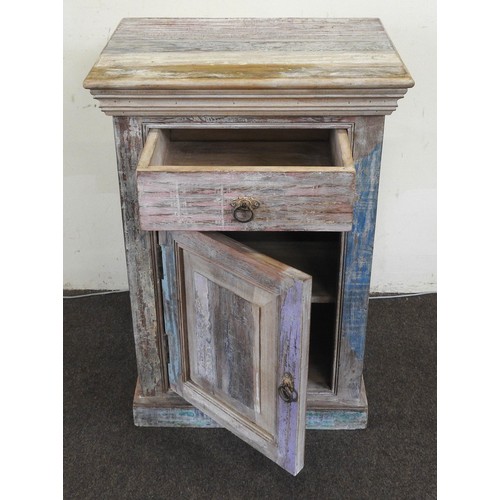 94 - A POLYCHROME PAINTED INDIAN TEAK BEDSIDE CUPBOARD, plain square form with frieze drawer above a pane... 