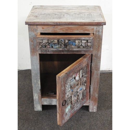 93 - A CHALK PAINTED POLYCHROME INDIAN HARDWOOD BEDSIDE CUPBOARD, the frieze drawer and door with a moasi... 