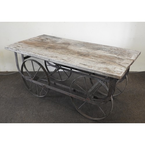 103 - A WROUGHT-IRON AND HARDWOOD PORTER'S TRUCK, the distressed plank top platform raised on a wrought-ir... 