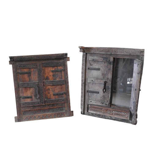 119 - TWO RUSTIC INDIAN HARDWOOD FRAMED MIRRORS, the plate of each mirror enclosed by iron mounted shutter... 