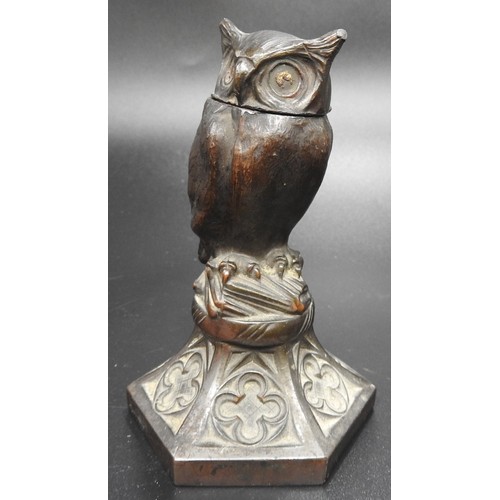 421 - A 19TH CENTURY SPELTER INKWELL, modelled as an owl stood atop a pile of books, raised on a hexagonal... 