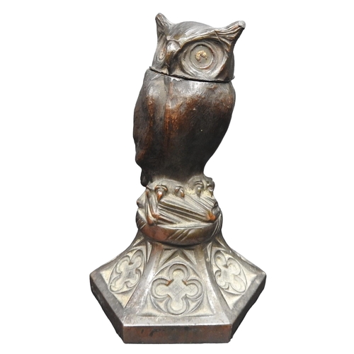 421 - A 19TH CENTURY SPELTER INKWELL, modelled as an owl stood atop a pile of books, raised on a hexagonal... 