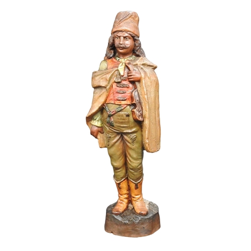 311 - A PAINTED POTTERY FIGURE, LATE 19TH/EARLY 20TH CENTURY, of a Moorish gypsy violinist, modelled stand... 