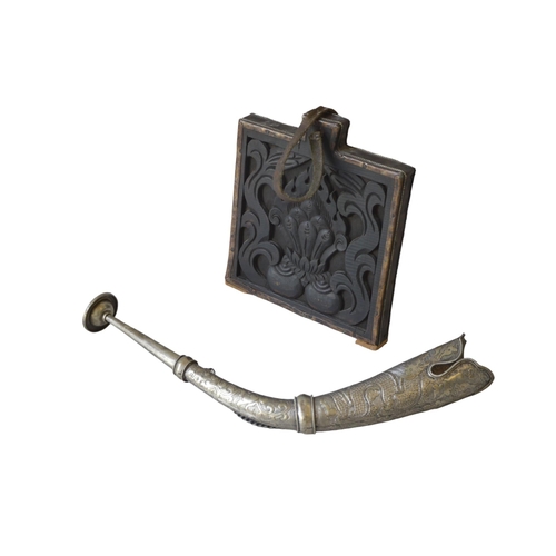 217 - A TIBETAN WHITE METAL HORN AND A BHUTANESE BUDDHIST PRINTING BLOCK, the curved horn with profuse cha... 