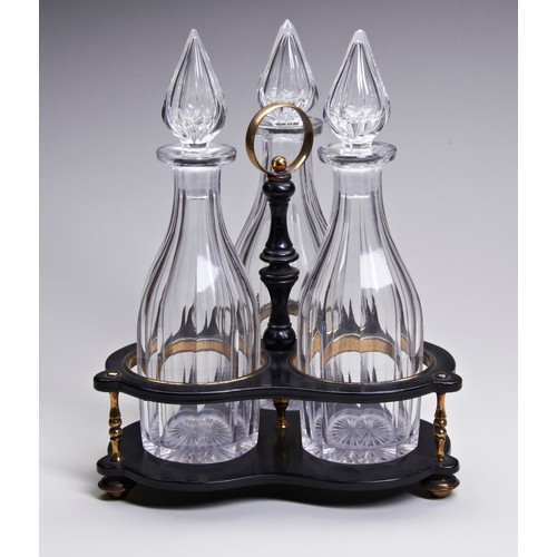 771 - A TRIO OF VINTAGE GLASS DECANTERS, with faceted bodies and finial stoppers, on a galleried trefoil f... 