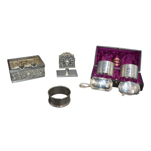 812 - A MIXED GROUP OF SILVER WARES, the lot includes two decanter labels, a pair of napkin rings, single ... 