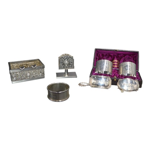 812 - A MIXED GROUP OF SILVER WARES, the lot includes two decanter labels, a pair of napkin rings, single ... 