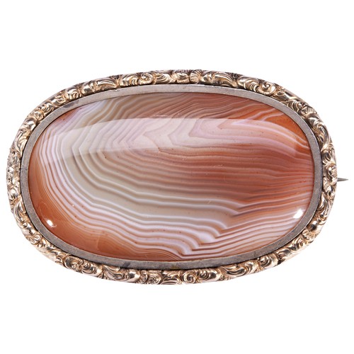 549 - AN AGATE AND GOLD BROOCH, CIRCA 1840the oval agate plaque within a chased foliate border.Brooch pin ... 