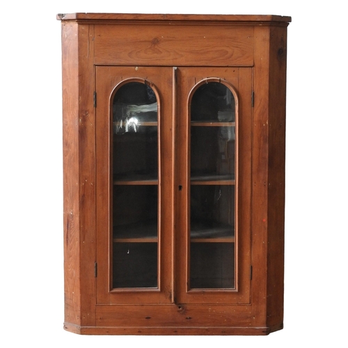 4 - A WAXED PINE CORNER CABINET, the arch glazed doors opening to reveal three interior shelves111 x 55 ... 