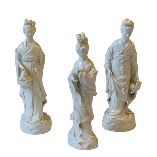 158 - THREE CHINESE BLANC DE CHINE FIGURINES, depicting female courtiers, each modelled standing in flowin... 