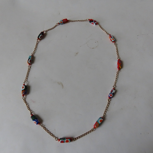 530 - MURANO GLASS NECKLACE, the eleven beads with bright abstract decoration on a gilt chain.Total weight... 