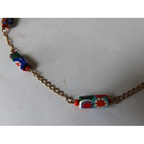 530 - MURANO GLASS NECKLACE, the eleven beads with bright abstract decoration on a gilt chain.Total weight... 