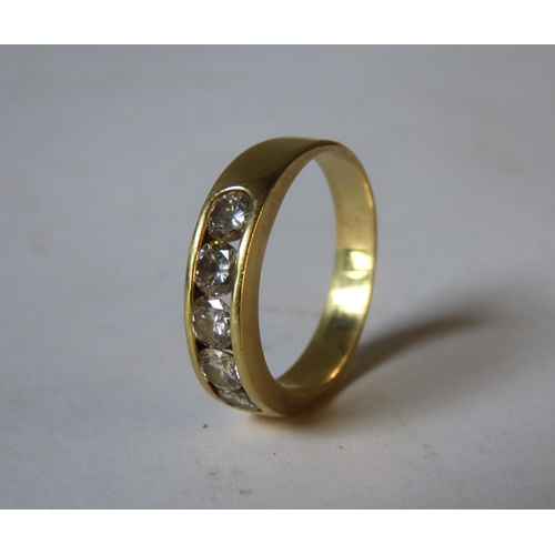 563 - A GOLD RING SET WITH FIVE BRILLIANT CUT DIAMONDS, set within a recessed mount, the shank stamped 18k... 