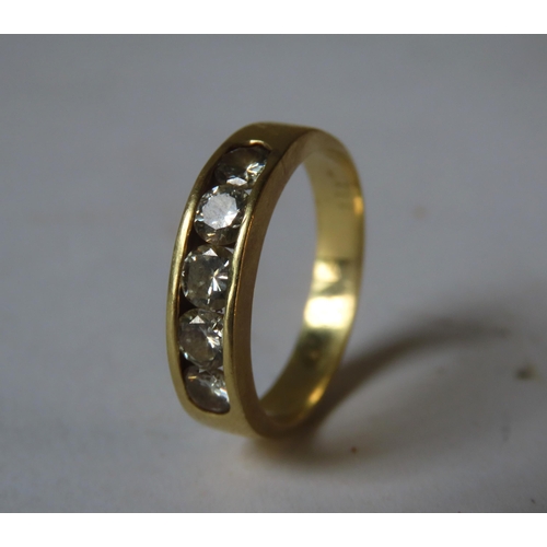 563 - A GOLD RING SET WITH FIVE BRILLIANT CUT DIAMONDS, set within a recessed mount, the shank stamped 18k... 