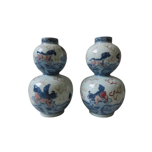 150 - PAIR OF UNDERGLAZE BLUE AND COPPER RED DOUBLE GOURD VASES 20TH CENTURY with apocryphal Kangxi six ch... 