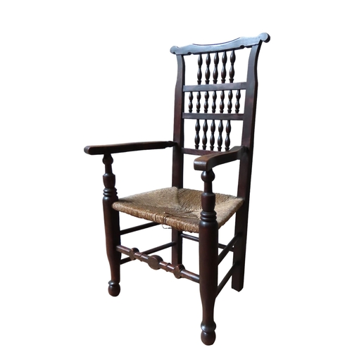 50 - AN EARLY 19TH CENTURY LANCASHIRE SPINDLE BACK ELM CHAIR, the rush seat panel flanked by serpentine f... 