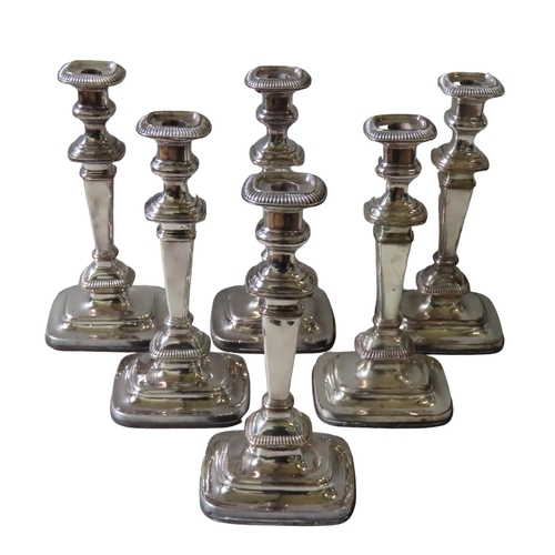 588 - A GROUP OF SIX SILVER PLATED CANDLESTICKS, gadrooned edge sconces on tapering rectangular knopped pi... 