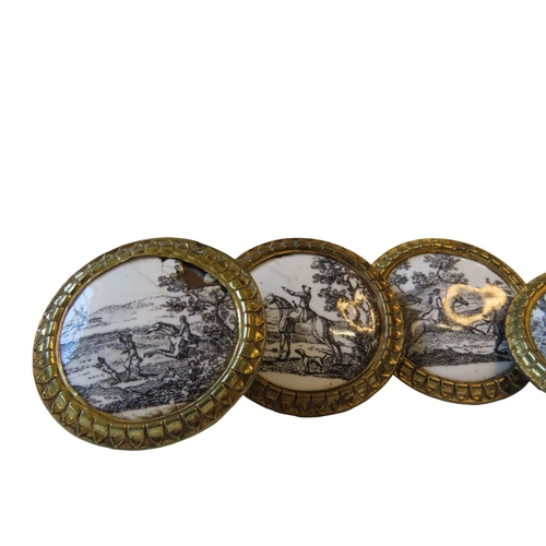 600 - A SET OF FIVE FRENCH ENAMELLED GILT BRASS HANDLES, decorated with black and white hunting scenes and... 