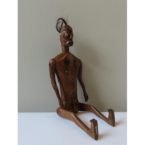 619 - AN AFRICAN ARTICULATED WOODEN MALE FERTILITY FIGURE with tufted hair and bone inset eyes.40 cms... 