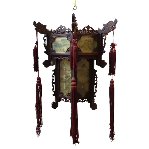 328 - A CHINESE HEXAGONAL FRET CARVED LANTERN SHADE, with carved dragon head decoration, the glass panels ... 